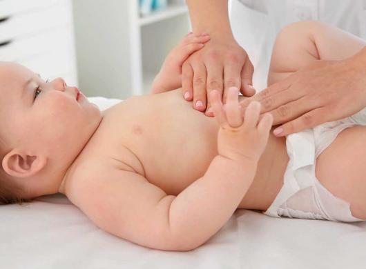 photo of a healthcare professional massaging the belly of a baby